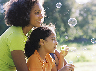 woman and daughter blowing bubbles